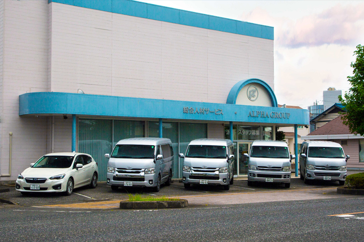 Fachada Alpha Group Oizumi e carros da empresa